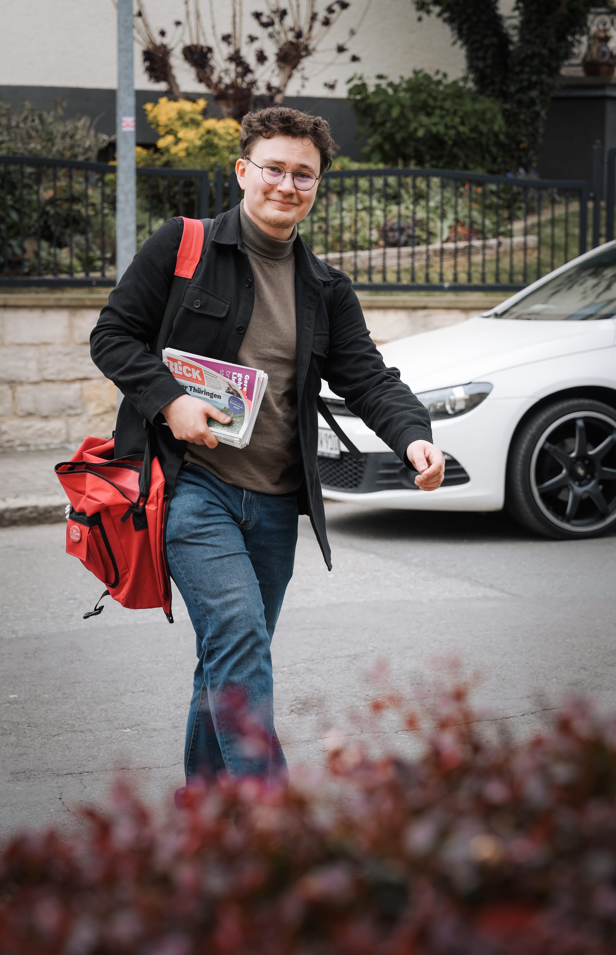 Leon Walter läuft mit einem Stoß Wahlkampfzeitungen in der Hand und einer roten Umhängetasche durch Ronneburg.